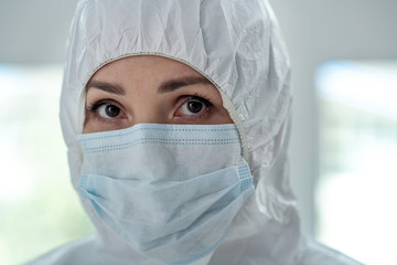 Close-up of female medical worker in protective clothing and medical mask