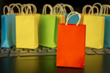 online shopping concept. little colorful shopping bags stand on laptop. copy space