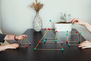 Mother and son  making geometric shapes from sticks and play dough.