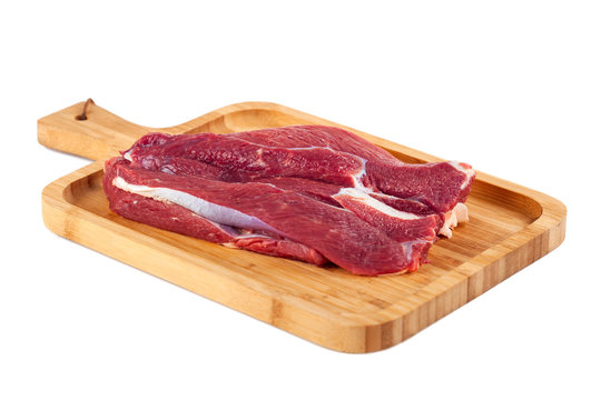Raw meat on wooden board isolated on white background