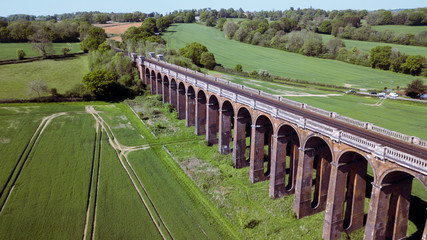 Aerial countryside shot of a train bridge. England