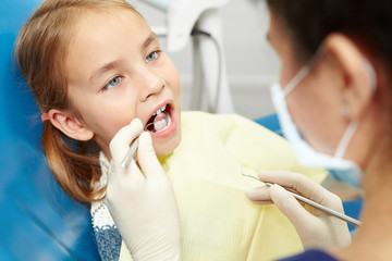 Little girl on a visit to the dentist in office of pediatric dentistry.