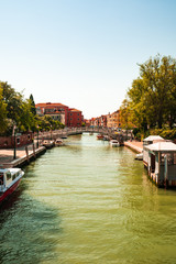 Venice canal on a summers day with boats moored on the side