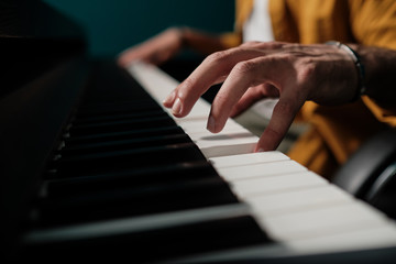 Obraz premium Male hands playing keyboard at the studio