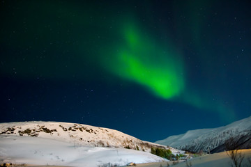 Zorza polarna nad zaśnieżonym wzgórzem. Zorza w Norwegii - obrazy, fototapety, plakaty