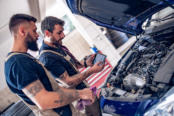 Young mechanics working in auto service