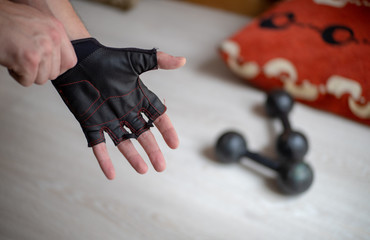 A Man Hand wearing Gym exercise Gloves at home quarantine