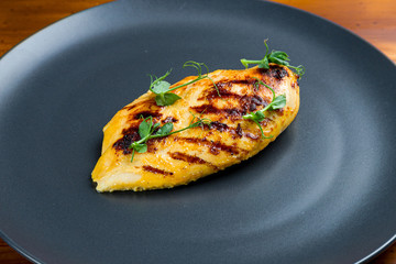 Grilled chicken Breasts on black plate