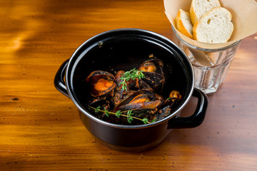 Mussels in tomato sauce on wooden table