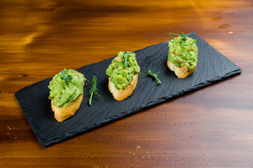 bruschetta with avocado on wooden table