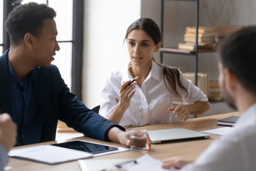 Attractive mentor businesswoman talking and conducts training in boardroom at company meeting....