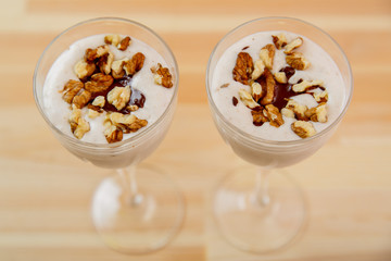 Glasses with ready smoothie chocolate ice cream banana smoothie and nuts.