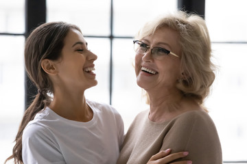 Close up laughing mature mother and adult daughter enjoying tender moment. Happy relaxing young...