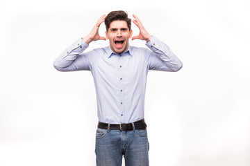 Fototapeta premium Young man screaming mouth open, hold head hand, wear casual blue shirt, isolated white background.