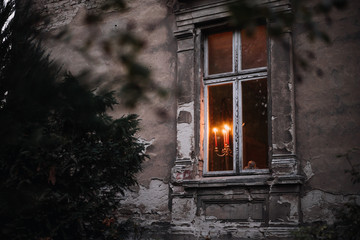Fototapeta na wymiar photo of an old house window with candles inside