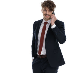 Fototapeta premium Positive businessman talking on phone and smiling