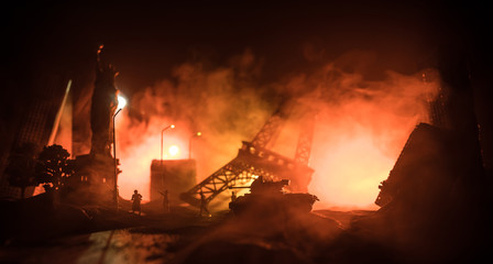 Empty street of burnt up city, flames on the ground and blasts with smoke in the distance. Apocalyptic view of city downtown as disaster film poster concept. Night scene. City destroyed by war.