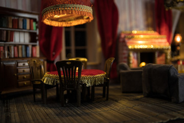 A realistic dollhouse living room with furniture and window at night. Artwork table decoration with handmade realistic dollhouse.