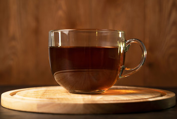 Transparent Cup with fragrant black tea on a blackboard on a natural background. Concept for your design, advertising.