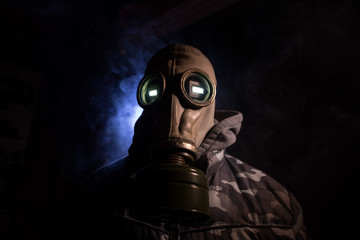 Gas mask with clouds of smoke on a dark background. Sign of radioactive contamination. Means for radiation protection. Danger of carbon monoxide poisoning.