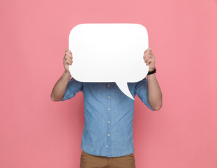 casual guy hiding face from camera behind a speech bubble