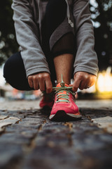 Young woman tying shoelaces in preparation of running 