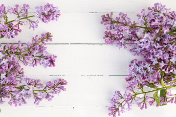 Flower composition. Frame of lilac flowers on a white wooden background. Flat lay, space for text.