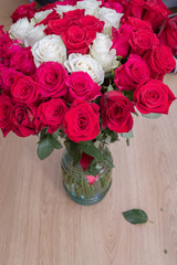 Obraz premium Multi-colored bouquet of red, pink and white roses in a vase