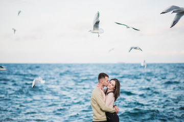 Seagulls fly over gorgeous happy young couple