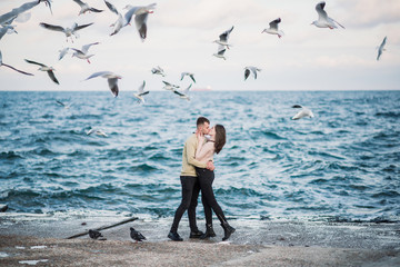 Fototapeta na wymiar Seagulls fly over gorgeous happy young couple