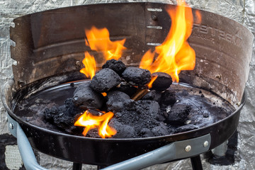 Lighting a charcoal grill. Flames.