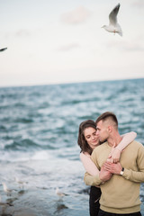 Fototapeta na wymiar Seagulls fly over gorgeous happy young couple
