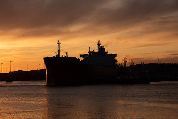 Obraz premium Silhouette of an oil tanker at sunset.