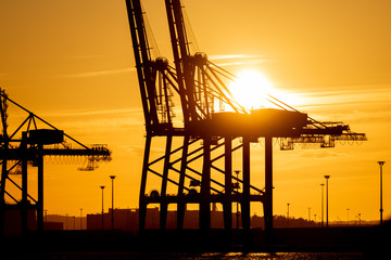 Large ship to shore container cranes at sunset..