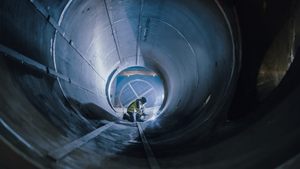Professional Heavy Industry Worker Wearing Helmet Welding Inside Oil and Gas Pipe. Construction of...