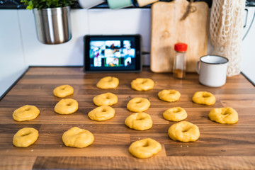 Close up of a Woman preparing homemade donuts in her kitchen following a recipe online. Baker concept