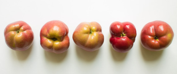 Five curves of ripe red apples close-up isolated. Trend-ugliness