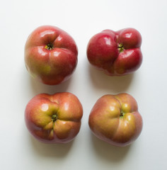 Four curves of ripe red apples close-up isolated. Trend-ugli fruit