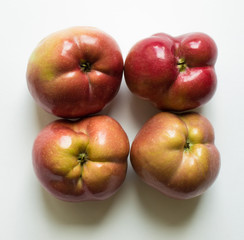 Four curves of ripe red apples close-up isolated. Trend-ugli fruit