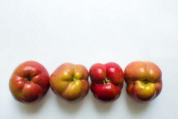 Four curves of ripe red apples close-up isolated. Trend-ugli fruit