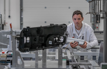 Quality engineer performs 3D measurements of plastic castings with the help of a robot for the automotive industry