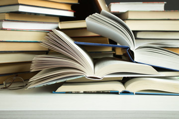Clutter on the table - a lot of open and closed books close-up