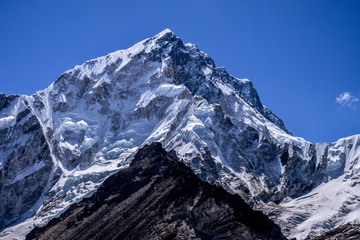Snow mountain peak of nepal himalayas in background with dark mountains in foreground  © Jon Fonte