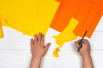 Close-up shot of two pairs of little pens cutting scissors from paper for craft on a white wooden table. View from above.