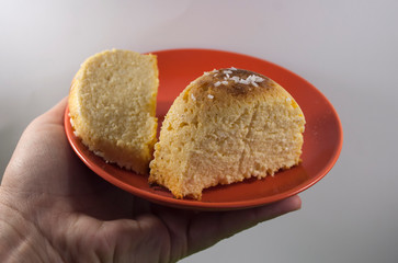 homemade cheesecake serving on red plate on palm