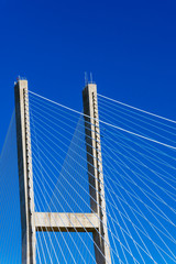 Abstract detail of a suspension bridge against a the sky, and represents the concept of infrastructure.