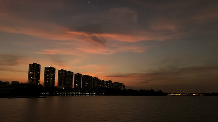 Fototapeta premium The nice lake with slope building background in bangkok city and dramatic sky mood and tone.