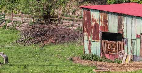 Old aged and weathered little farmhouse shed on a green field