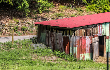 Old aged and weathered little farmhouse shed on a green field
