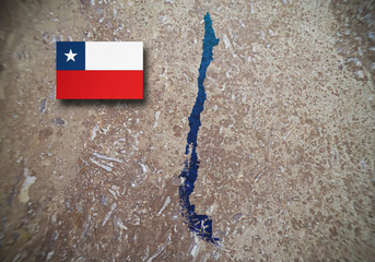 Map and flag of Chile on a concrete background, blurred image.